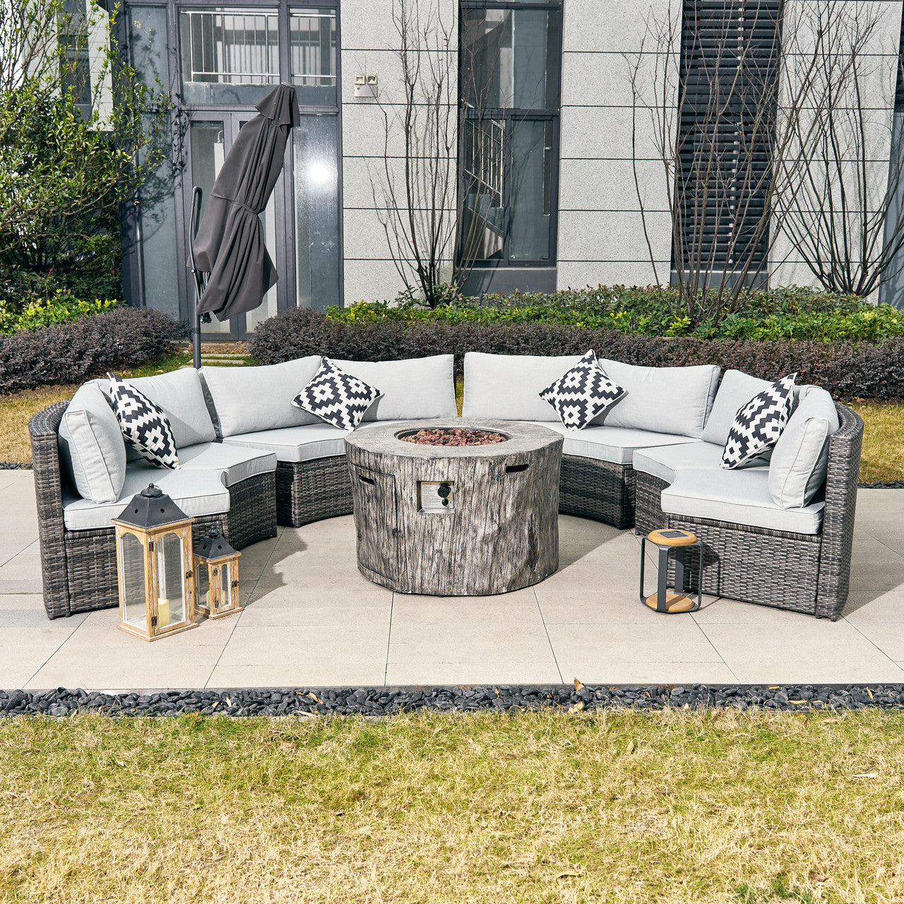 An elegant outdoor set with wicker sofa and fire pit table.