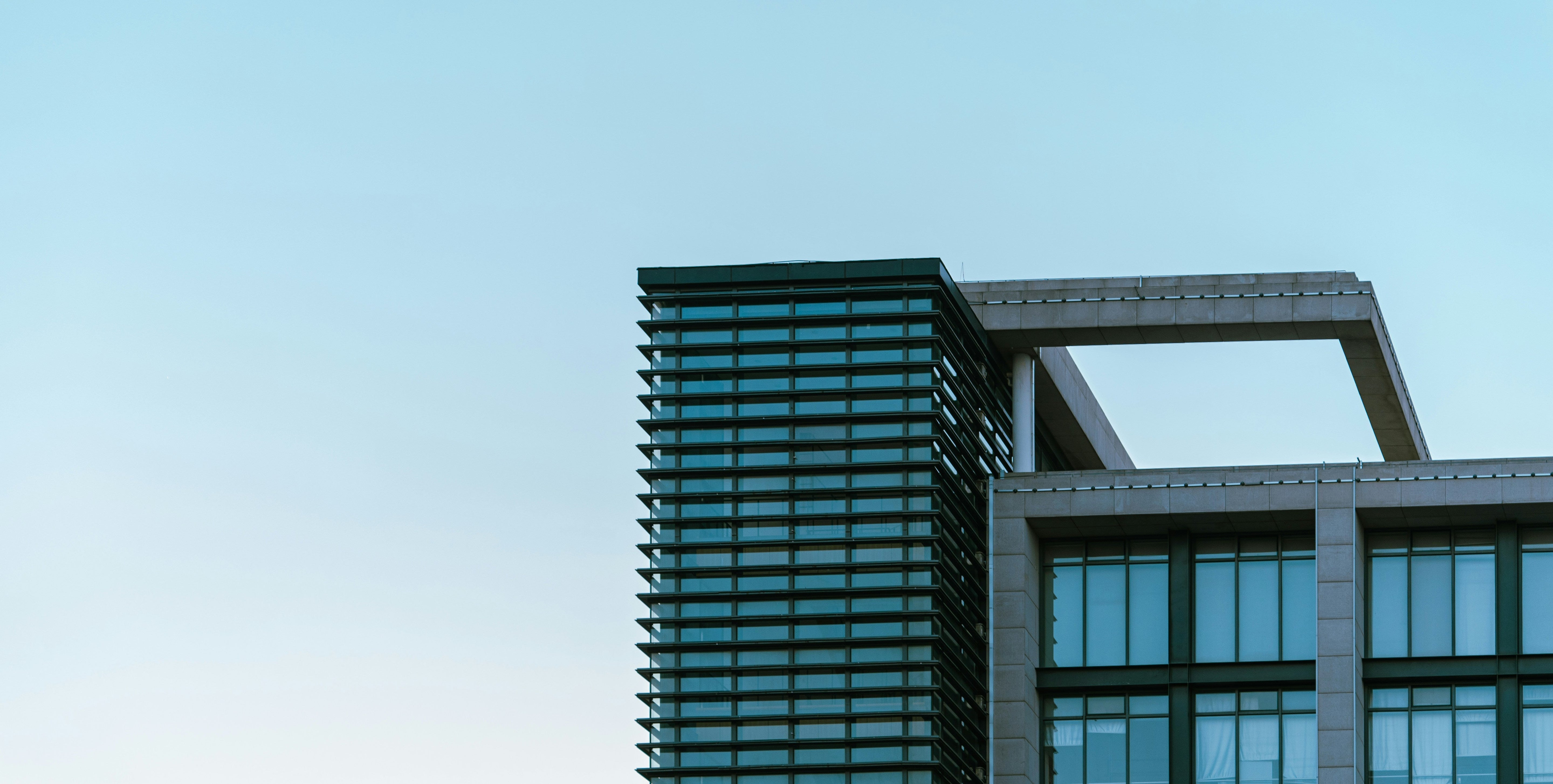 Direct Wicker About-Us page banner-Modern building with glass facade against a clear blue sky